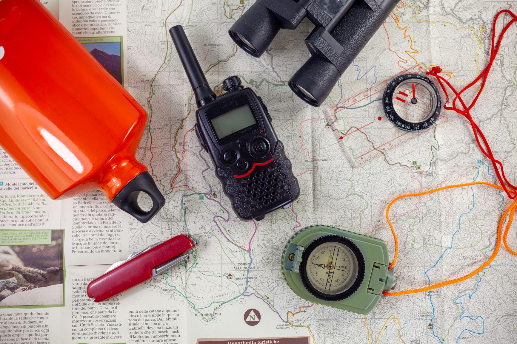 Tools For Camping & Survival A picture with various tools for survival and camping scattered about on a map.