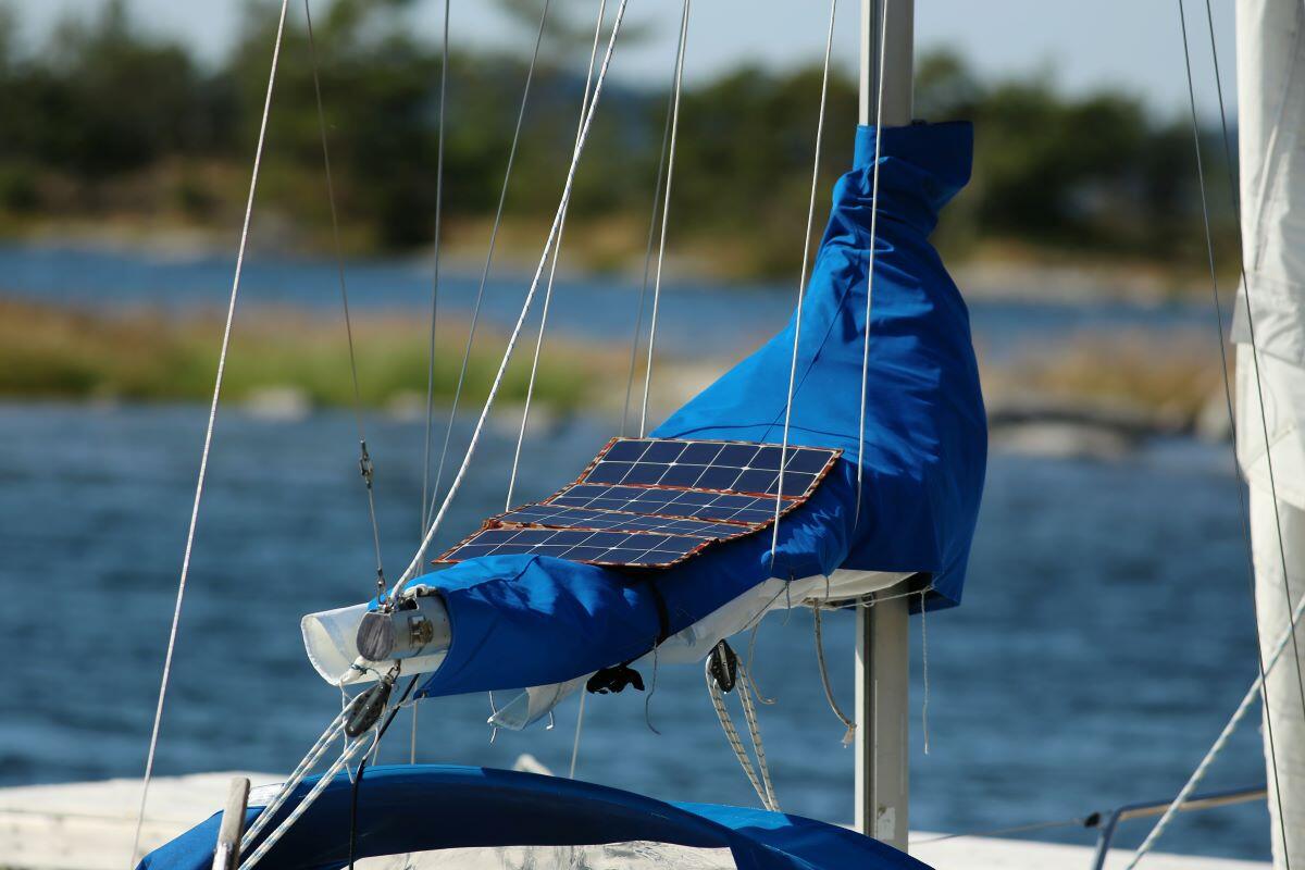 Picture of a sail boat with a solar panel sitting on top of a blue sail.
