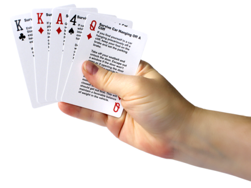Hand with playing cards that are used for a survival game.