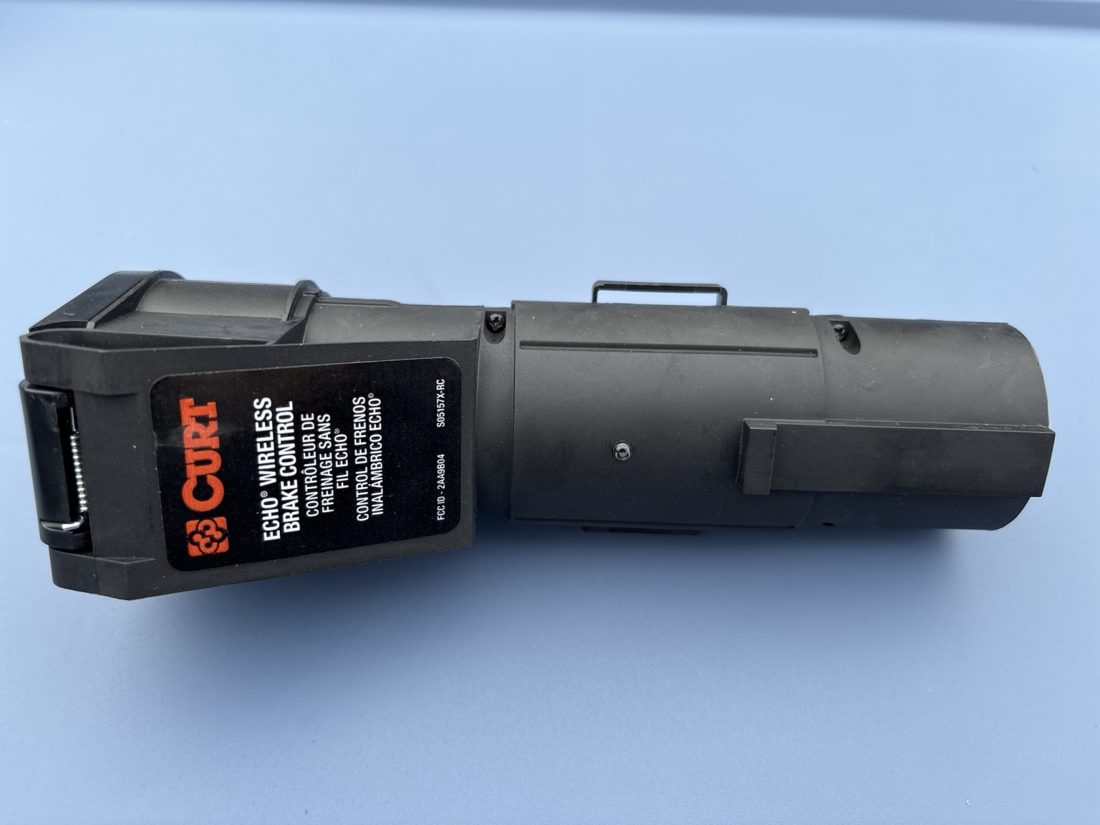 CURT Echo Mobile trailer brake controller on a blue surface