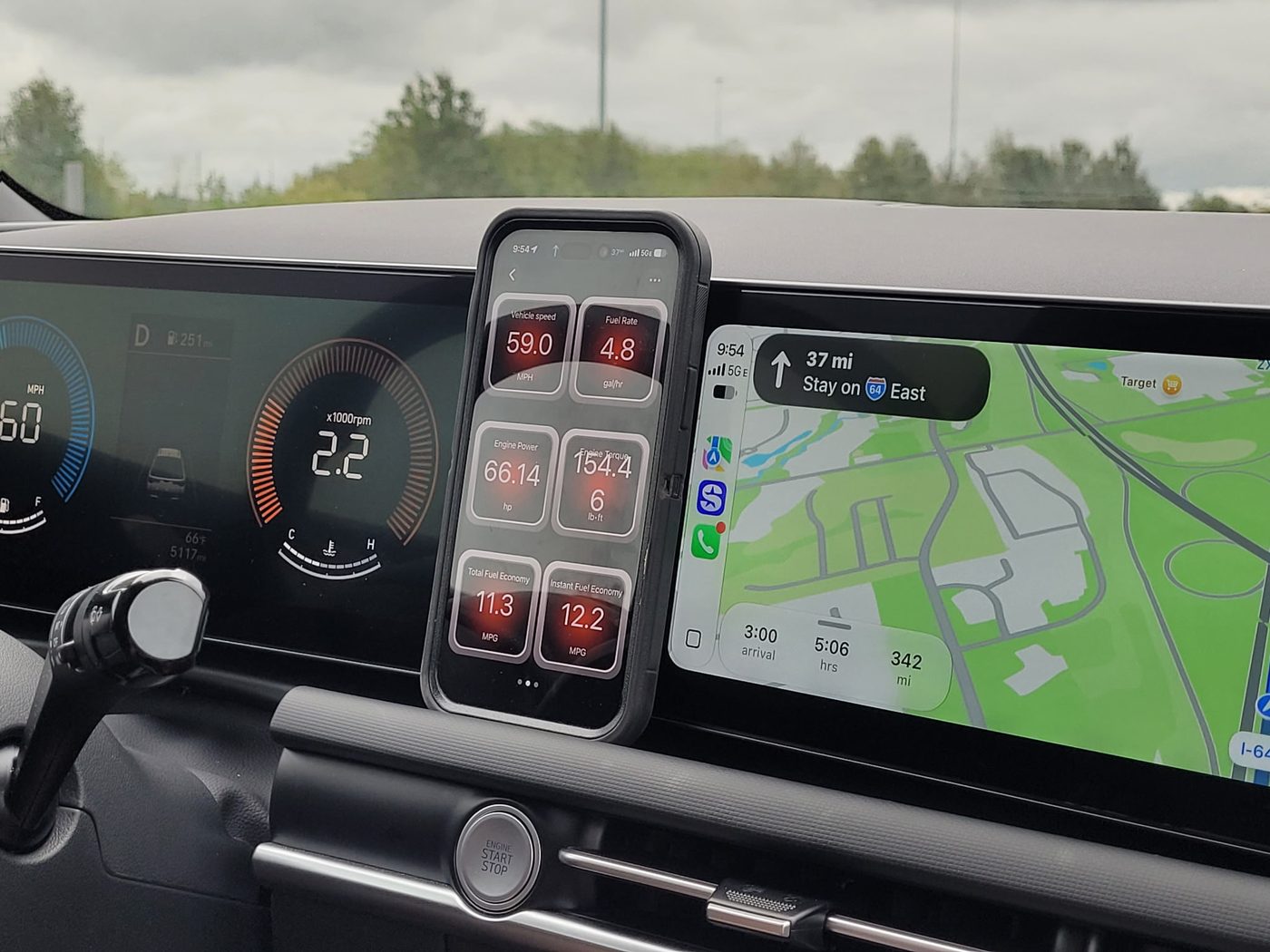 Phone showing OBDLink towing gauges beside the Hyundai Santa Cruz dashboard and navigation