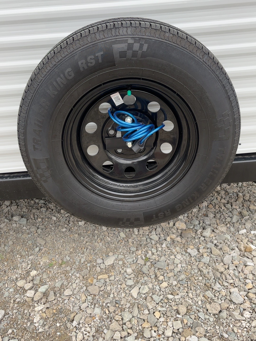 Blue cable threaded through the travel trailer spare wheel