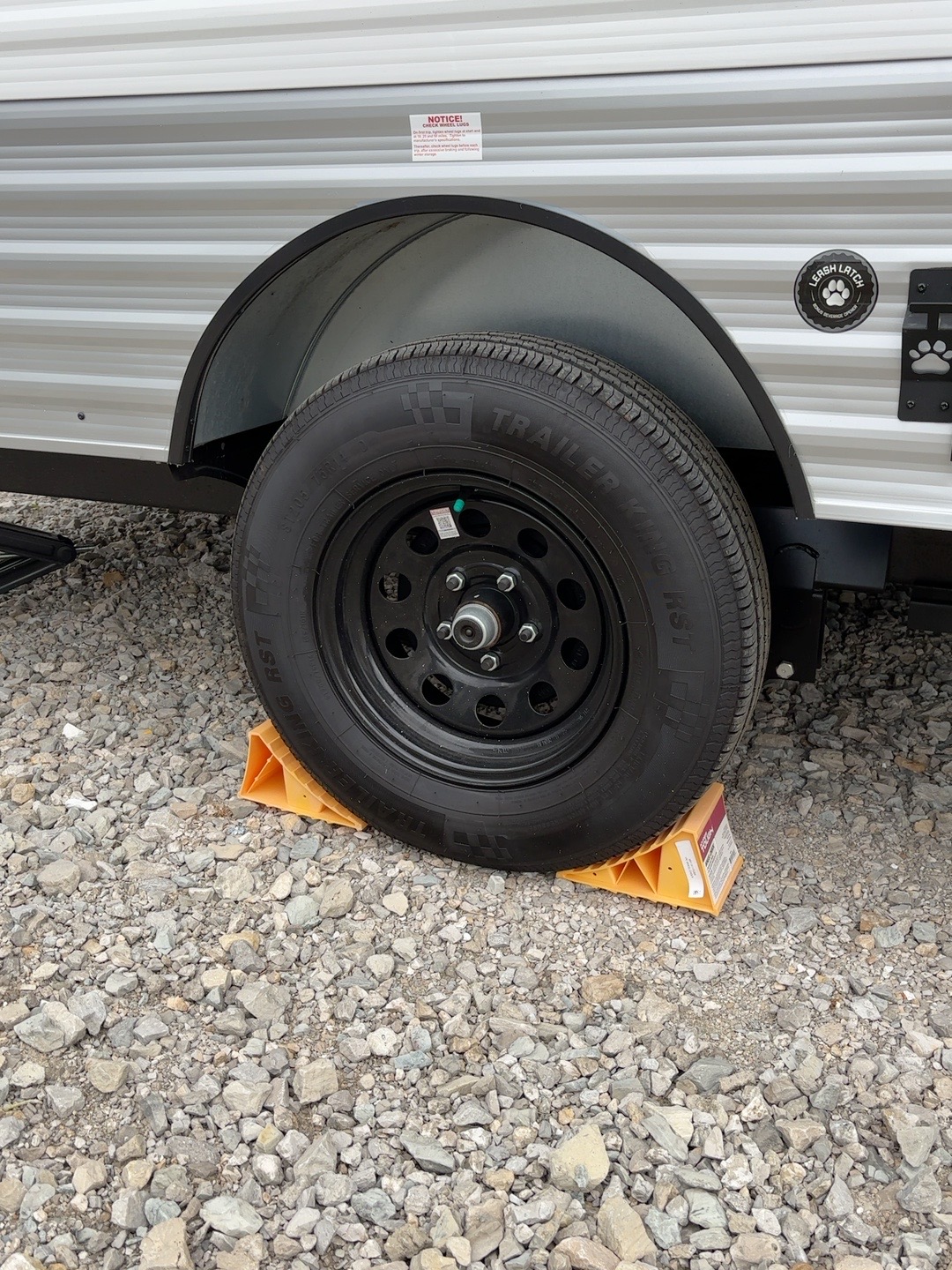 Wheel chocks placed around a parked travel trailer tire