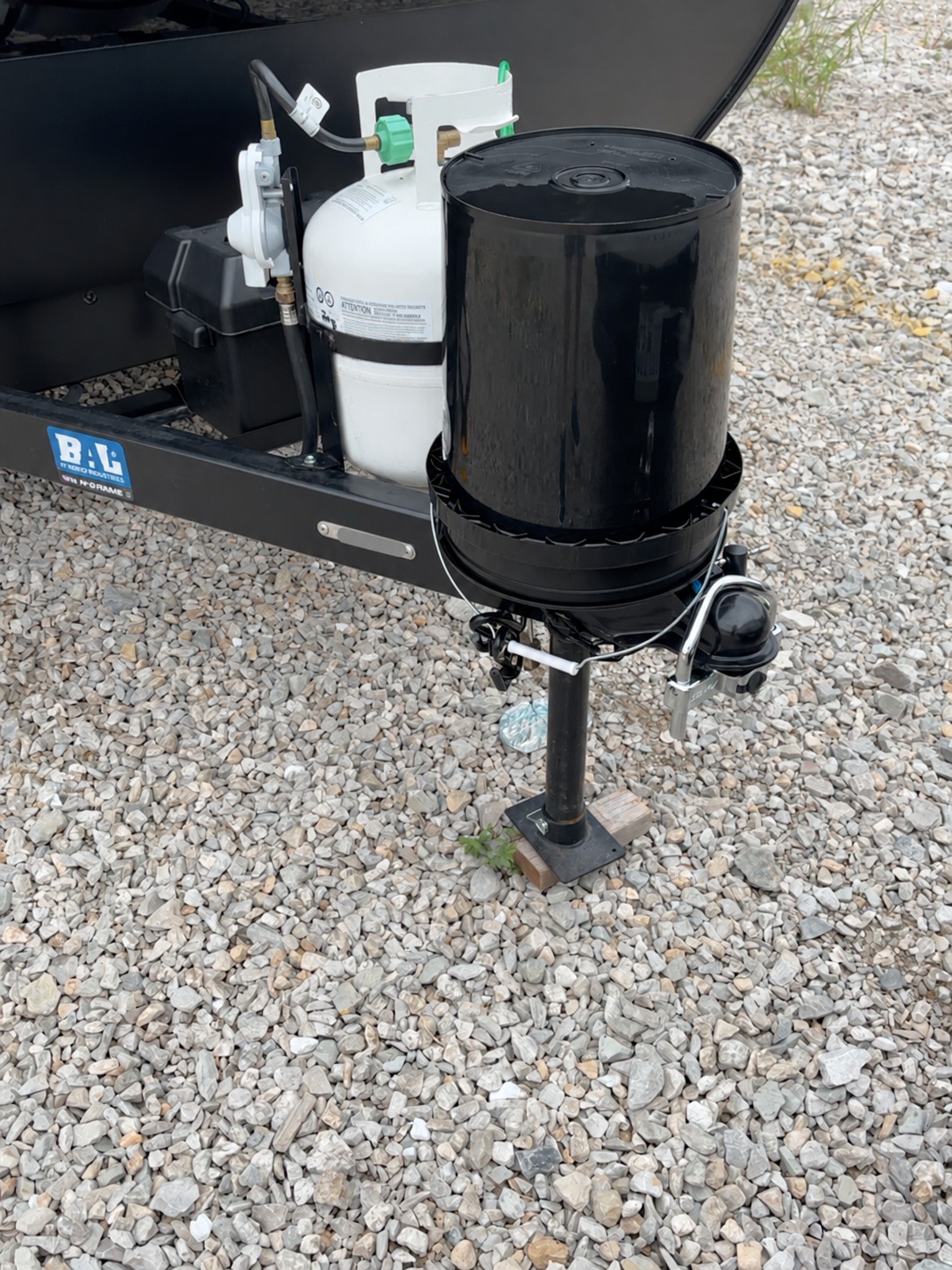 Parked travel trailer tongue with coupler lock and jack; VIN obscured