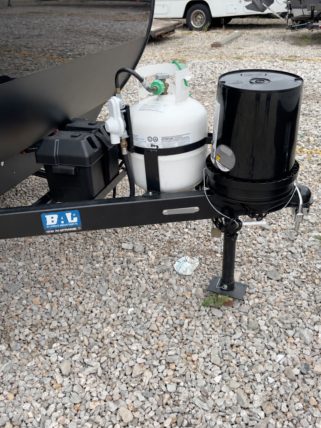 Trailer tongue with covered coupler and propane tank while parked